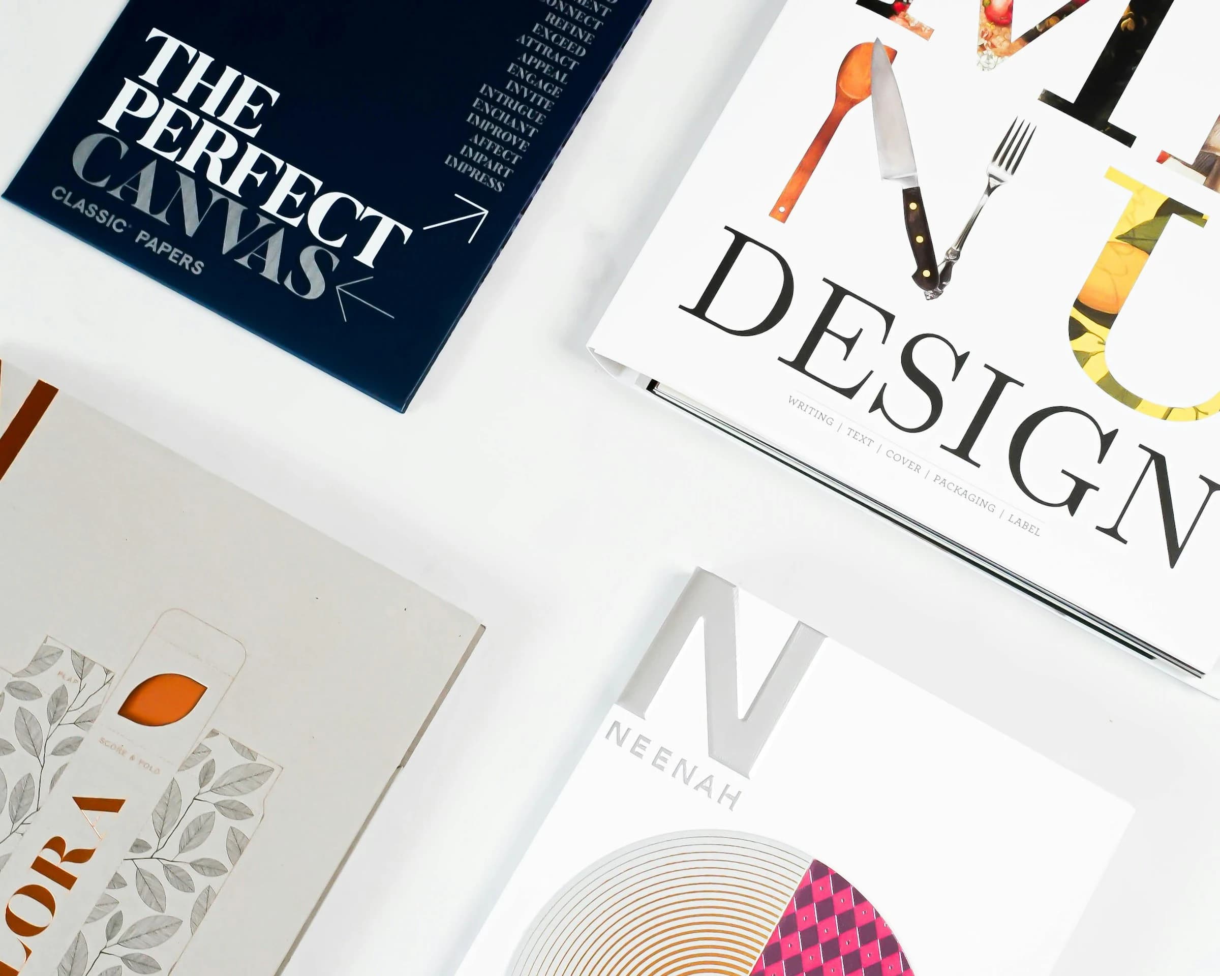 Buku desain dan contoh kertas tertata di atas meja